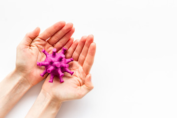 Corona virus Covid-19 - diagnostics concept with strain virus model and hands - on white background top-down copy space