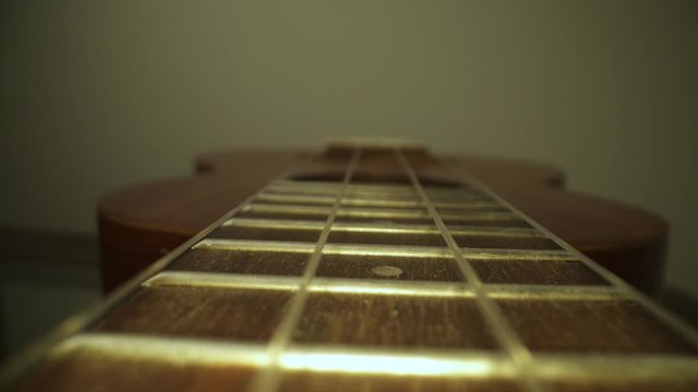 Ukulele neck fingerboard close up dolly shot