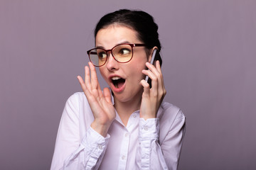 girl in a white shirt and glasses communicates on the phone