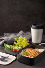 Healthy lunch at office workplace. Takeaway lunch boxes with nutrition food - fish, vegetables and fruits at working desk