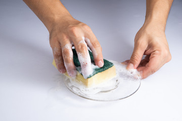 washing clear glass by bare hand and sponge foam on white background stock photo