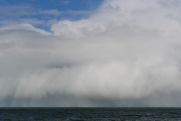 Weather is changing rapidly by the sea. Huge rain clouds are approaching.