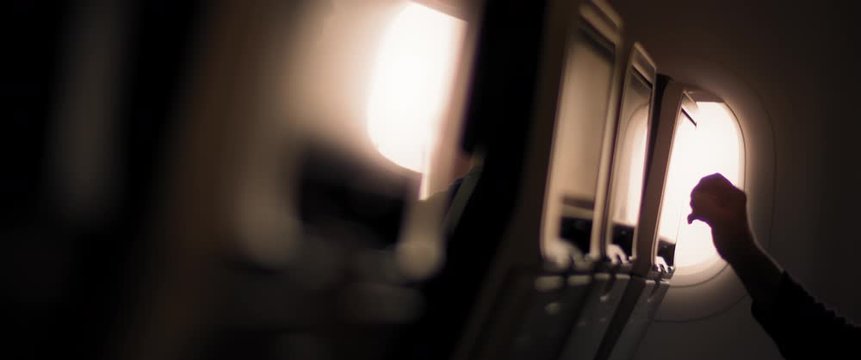 Passenger using airplane entertainment touch screen during the flight.  Adventure, travel, journey concept. SLOW MOTION, SHALLOW DOF, BMPCC 4K.
