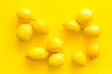 Lemons background - whole fruits - on yellow table top-down