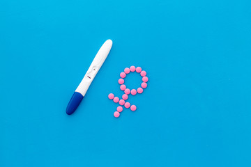Pregnancy test with two strips and Venus sign - baby girl expectation - on blue background top-down