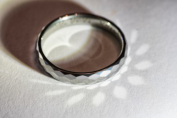 Tungsten ring lying with light reflection.