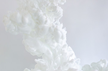 Blurred and focus white poster color dissolving in water for abstract and backgorund concept.