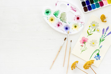 Watercolor painting. Picture with flowers, paints, palette on white background top-down copy space
