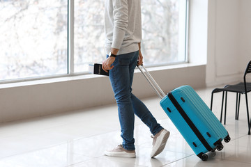 Young man waiting for his flight at the airport