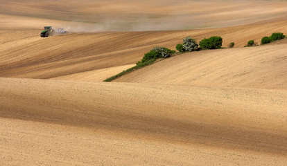 Obraz premium Agricultural work in the field. Hilly slopes. Textured patterns of fields.