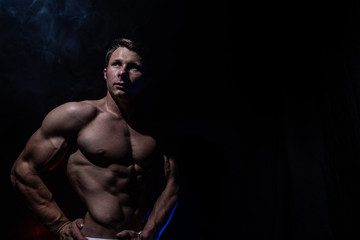 Fototapeta na wymiar Muscular man showing muscles isolated on the black background. Concept of bodybuilding and creating your body at gym 