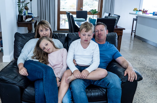 COVID-19 Outbrek. Bored family confined to their home watching tv during coronavirus lockdown