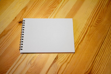 木のテーブルの上の白いノート a white notebook on a wooden table