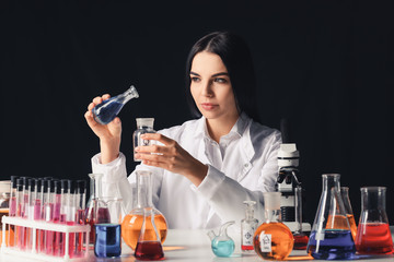 Female alchemist with potions at table