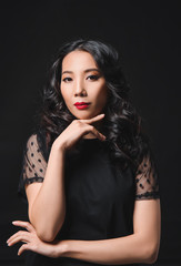 Naklejka premium Young Asian woman with beautiful hair on dark background