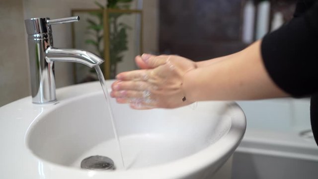 Correct way to wash hands concept. Caucasian woman washing and cleaning hands and fingers with soap and water