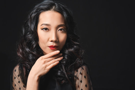 Young Asian Woman With Beautiful Hair On Dark Background