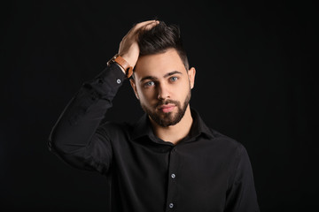 Handsome man with healthy hair on dark background