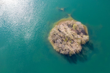 An isolated island surrounded by blue water in spring