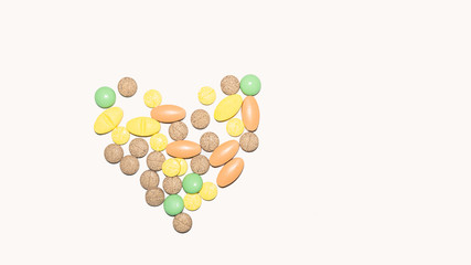 Heart shaped colorful tablets on a white background
