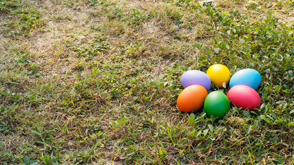 Easter eggs in many colors on the grass. Red egg, blue egg, yellow egg