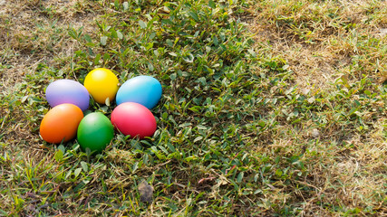 Easter eggs in many colors on the grass. Red egg, blue egg, yellow egg