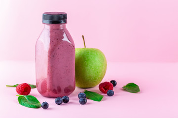 Colourful healthy smoothies and juices in bottles on color background with copy space.