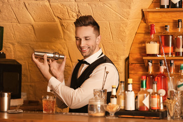 Male bartender making cocktail in pub