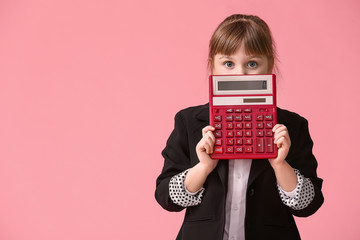 Little girl with calculator on color background