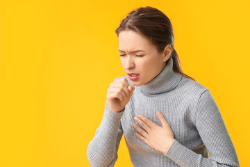 Ill coughing young woman on color background - obrazy, fototapety, plakaty