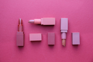 Different lipsticks on color background