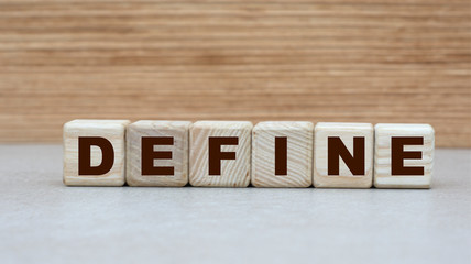 Naklejka premium concept of the word to define on cubes on a light wooden background
