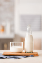 Glass and bottle of fresh milk on table