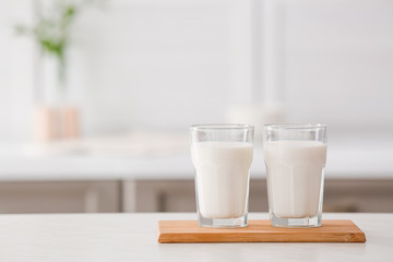Glasses of fresh milk on table
