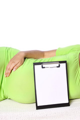 Happy pregnant girl expecting a baby with a tablet lies on a white background. Medicine for women message on tablet.