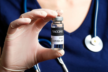 Nurse holding Coronavirus COVID-19 vaccine vial, close-up view
