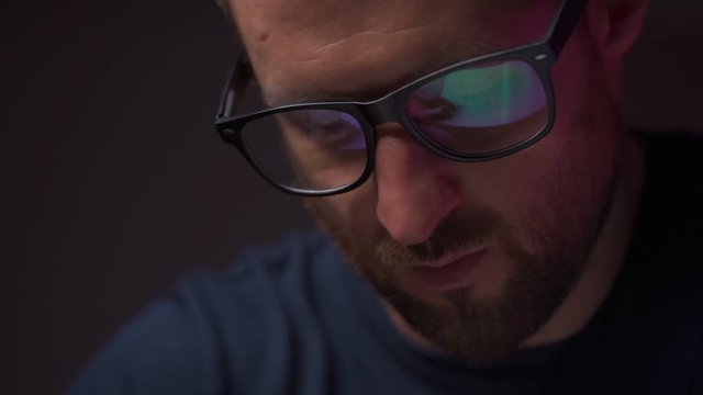Reflection in Men's Glasses. Office routine, a man writes in slow motion