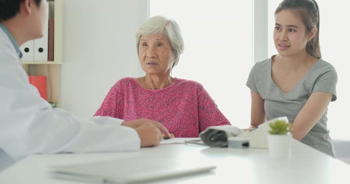 Friendly mature general practitioner communicating with pleasant 80s female patient. Smiling trustful middle aged doctor giving psychological help to elder woman. Health care and medical concept.