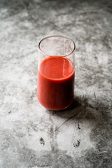 Healthy Organic Homemade Fresh Mixed Red Strawberry Smoothie with Banana, Grape, Apple and Orange in Glass.