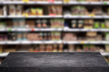 Black stone surface on blurry background at grocery store.