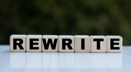 The concept of the word REWRITE on cubes on a beautiful green background