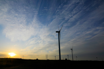 Fototapeta na wymiar The windmill in the sunset, on the hillside
