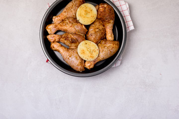Uncooked Chicken Legs with Spice and Onion on Black Plate Dinner Dish Ready to Cook Top View