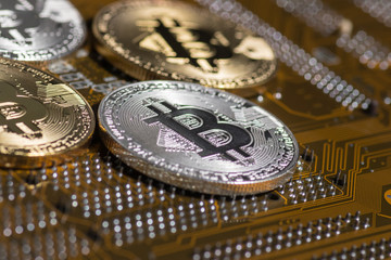 Golden silver crypto currency coin on motherboard. Shiny closeup crypto-currency coin background. Electronic money, cryptocurrency.