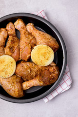 Uncooked Chicken Legs with Spice and Onion on Black Plate Dinner Dish Ready to Cook Vertical