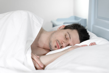 Fototapeta na wymiar young man sleeping in bed