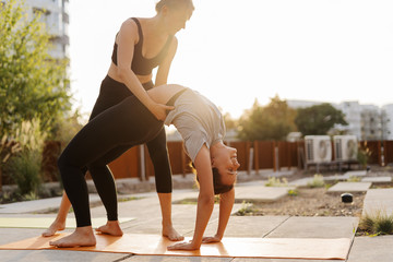Two young girls practicing stretching and yoga workout exercise together