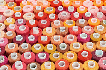 many bobbins of thread of different colors background
