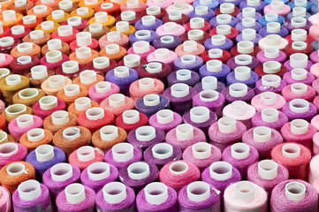 many bobbins of thread of different colors background