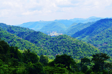 Mountains and trees under cloudy sky
